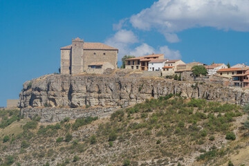 Vista panorámica de Moscardón al borde de un barranco en Teruel con su Iglesia de San Pedro  Apóstol  sobresaliendo sobre la población