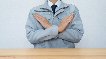 拒否のポーズ・作業服にネクタイの男性・建設業イメージ