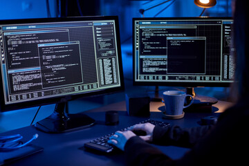 cybercrime, hacking and technology concept - close up of female hacker in dark room writing code or...