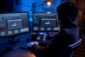 cybercrime, hacking and technology concept - female hacker in dark room writing code or using...