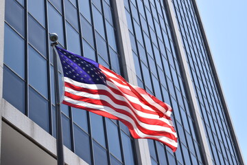 American flag in front of corporate head office. US corporation in big city - Powered by Adobe