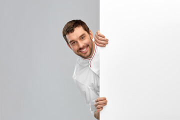 cooking, culinary and people concept - happy smiling male chef with big white board over grey...