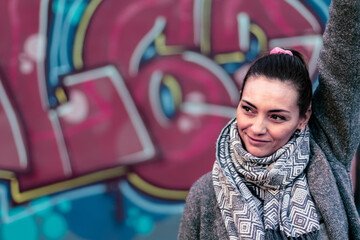 Portrait of an adult caucasian woman totally confidence in herself outdoors with a painted wall as background