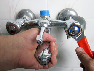     Man repair and fixing shower faucet in bathroom.          