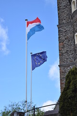 Luxembourg and European Union flags in front of an old building