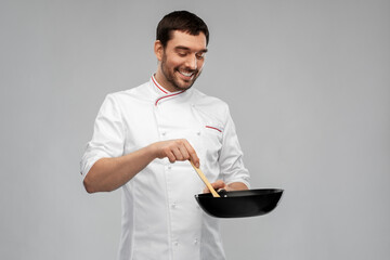 food cooking, culinary and people concept - happy smiling male chef in jacket with frying pan and...