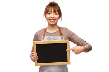 cooking, culinary and people concept - happy smiling female chef or waitress in apron with chalkboard over white background