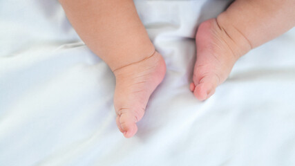 Fototapeta na wymiar Newborn chubby legs and foots. Beautiful conceptual image of motherhood and baby