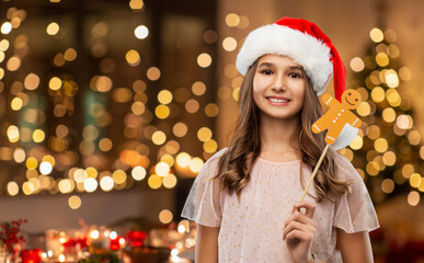 christmas, holidays and photo booth concept - happy smiling teenage girl in santa helper hat with...