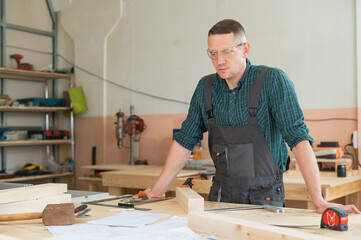 Portrait of a handsome male carpenter in the workshop.