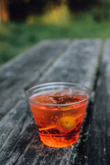 Aperol Spritz aperitif cocktail in plastic cup on picnic table