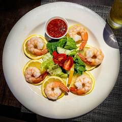 A plated shrimp cocktail appetizer arranged on a white plate