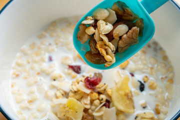 preparing healthy breakfast of milk with nuts and dry fruits and melon seeds