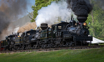 View of Three Shay Steam Engines, Heading Out for a Parade of Steam With All Three Engines Connected Together Blowing Black Smoke and White Steam on a Sunny Summer Day