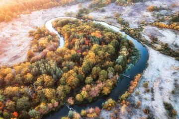 Drone view Autumn forest near the river in the meadow, cool frosty dawn.