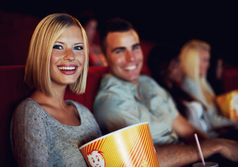 Movie, popcorn and smile with woman on a date with man at cinema interior or theater event. Happy,...