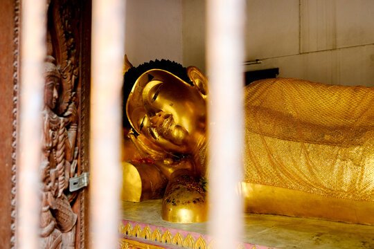Buddha amulet reclining posture, the Buddha image is in the right side of the Ariya Buddha image. His Majesty's feet overlap evenly. His left hand crosses his body in Thailand.