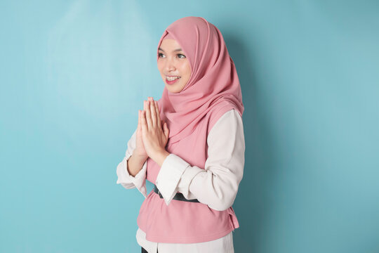 Portrait young beautiful Muslim woman wearing a pink hijab. Eid Mubarak greeting