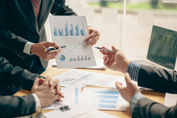 Team of business people meeting to analyze and find information, charts, financial reports, brainstorming, analyzing with consultants, accountants, finance, office teamwork concept.