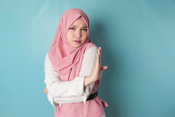 Beautiful Asian Muslim woman with hand gesture pose rejection or prohibition with copy space