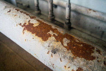 Steel pipe with blister paint, rust paint peeling off against the surface of the pipe.