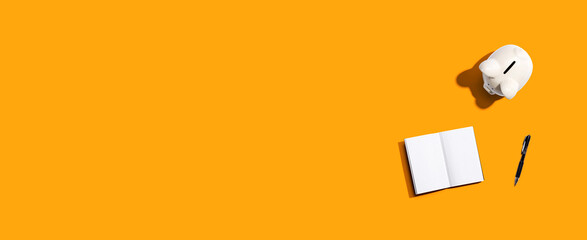 Piggy bank with a notebook - flat lay