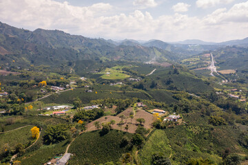 Fototapeta na wymiar Agricultural fields between hills with dirt roads between them in a Colombian landscape