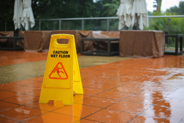 Caution wet floor yellow sign warning while it raining outside. Safety first and need to be clean....