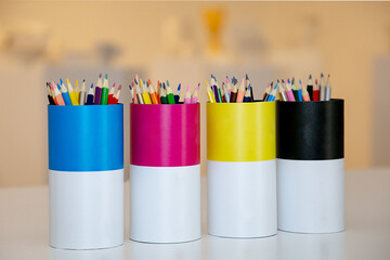 Colores y lápices en escritorio en envases editables, útiles escolares, concepto de talleres y...