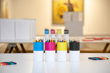 Colores y lápices en escritorio en envases editables, útiles escolares, concepto de talleres y...