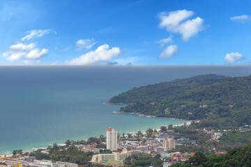 Karon Beach in Phuket Thailand, turquoise blue waters, lush green mountains colourful skies. Phuket is a tropical island many palms