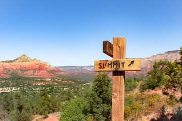 Summit sign and the red rock mountain cliffs at the Airport Mesa hiking trail in Sedona Arizona