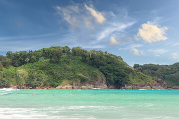 Fototapeta na wymiar Naiharn Beach in Phuket Thailand, turquoise blue waters, lush green mountains colourful skies. Phuket is a tropical island many palms
