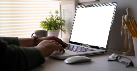 Back view creative woman working with laptop computer while sitting in modern office.