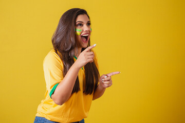 Woman supporter of Brazil, world cup 2022, football championship, surprised, amazing, pointing away...