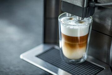 Espresso machine making fresh coffee latte. Shot of espresso being pour into fresh steamed milk