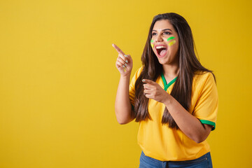 Woman supporter of Brazil, world cup 2022, football championship, surprised, amazing, pointing away...
