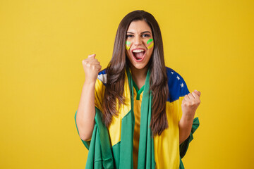 Fototapeta Woman supporter of Brazil, world cup 2022, soccer championship, using flag as cape, Partying and celebrating Brazil game. obraz