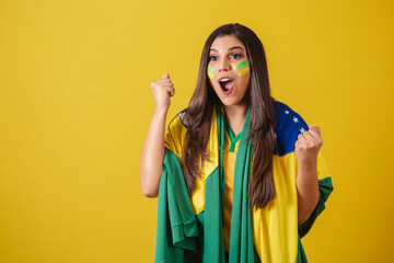 Woman supporter of Brazil, world cup 2022, soccer championship, using flag as cape, Partying and...
