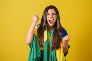 Woman supporter of Brazil, world cup 2022, football championship, using flag as a cape, screaming...