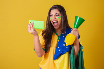 Woman supporter of Brazil, world cup 2022, soccer championship, watching the match on her cell...
