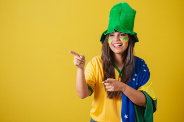 Woman supporter of Brazil, world cup 2022, pointing with fingers, announcing something, wearing...