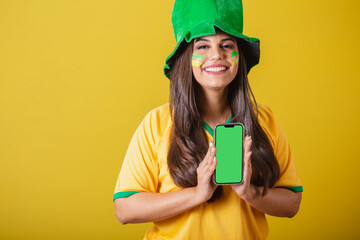 Woman supporter of Brazil, world cup 2022, holding cellphone and showing screen for apps.