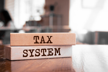 Tax System text concept written on wooden blocks lying on a table