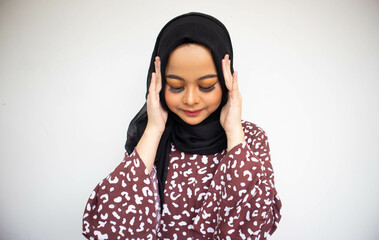Frustated Asian young woman in hijab isolated on white background holding head with headache