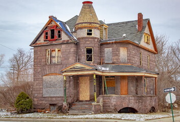 Old abandoned boarded up house in Detroit Michigan on a cloudy day