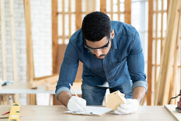 Professional carpenter designing model of house in the wood workshop