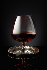 Snifter of brandy on a on a silver tray.