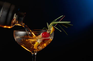 Cocktail with cherry, rosemary, and lemon.