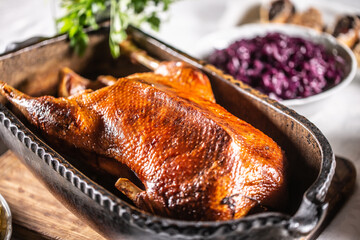Crispy baked goose in an original baking dish on the festive table